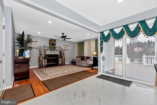 living room with a ceiling fan, recessed lighting, marble finish floor, and a fireplace