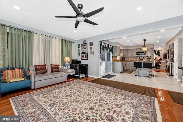 living room with baseboards, light wood-type flooring, and recessed lighting