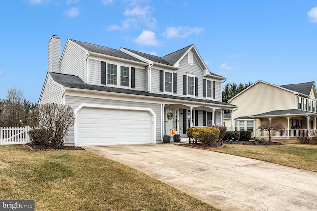 traditional-style home featuring driveway, a garage, fence, and a front yard