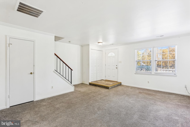 foyer entrance with carpet flooring