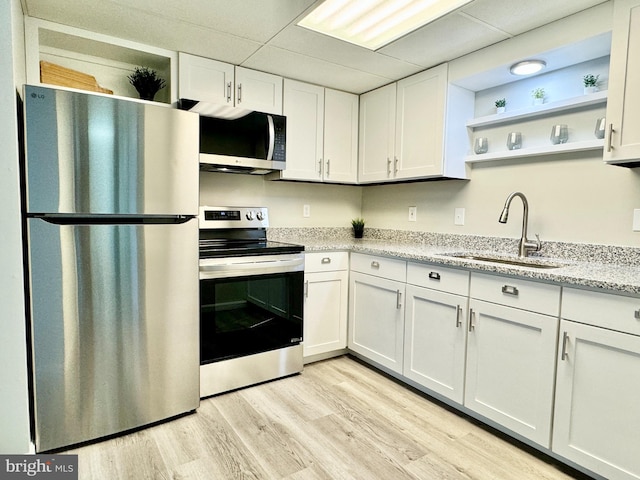 kitchen featuring appliances with stainless steel finishes, white cabinets, and open shelves