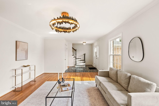 living area featuring ornamental molding, stairway, wood finished floors, and baseboards