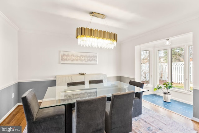 dining space with crown molding, baseboards, and wood finished floors