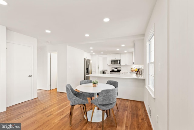 dining area with light wood-type flooring and recessed lighting