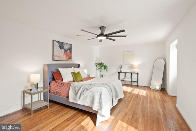 bedroom with light wood-style floors, baseboards, and a ceiling fan