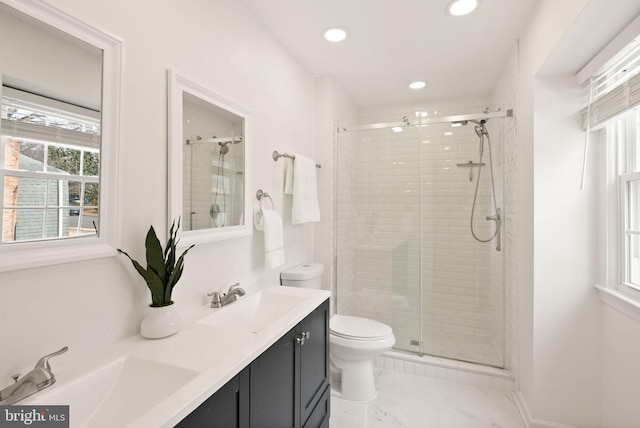 bathroom featuring toilet, a stall shower, double vanity, and a sink