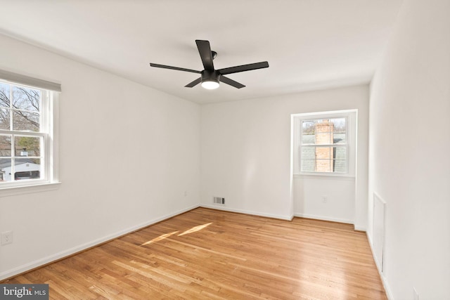 empty room with visible vents, ceiling fan, light wood-style flooring, and baseboards