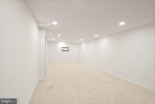 finished basement featuring light carpet, baseboards, and recessed lighting