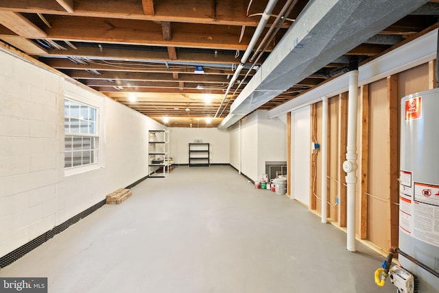 below grade area featuring gas water heater and concrete block wall