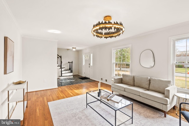 living area featuring crown molding, stairway, wood finished floors, and baseboards