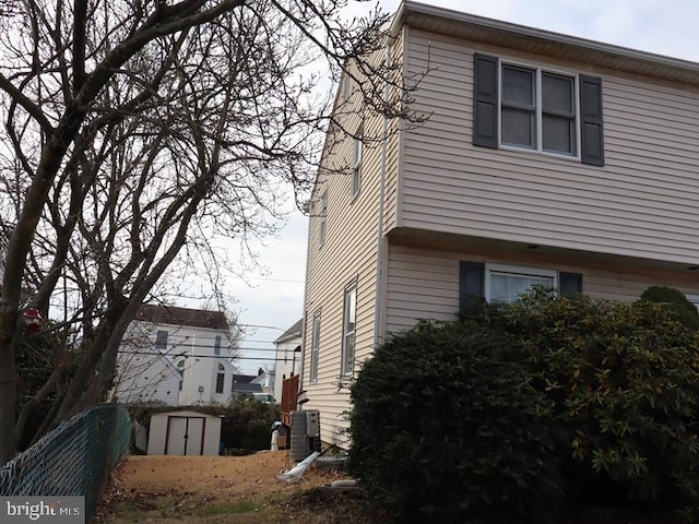 view of side of property with a storage unit and central AC