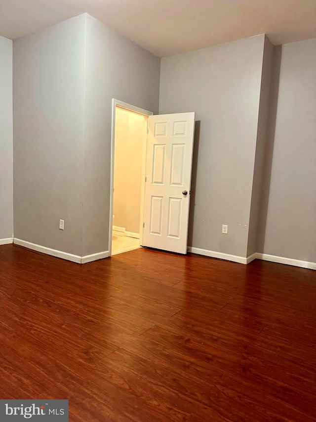 unfurnished room with baseboards and wood finished floors
