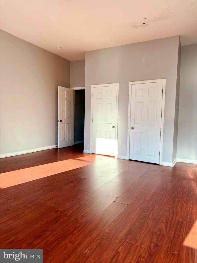 unfurnished bedroom featuring dark wood finished floors and baseboards
