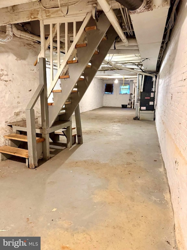 basement featuring heating unit and stairs
