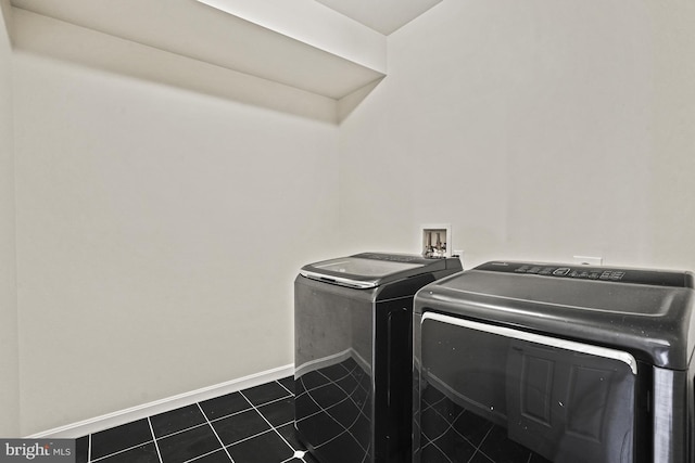 laundry room with dark tile patterned floors and washing machine and dryer