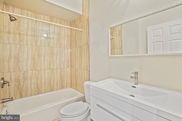 full bathroom featuring tiled shower / bath, vanity, and toilet