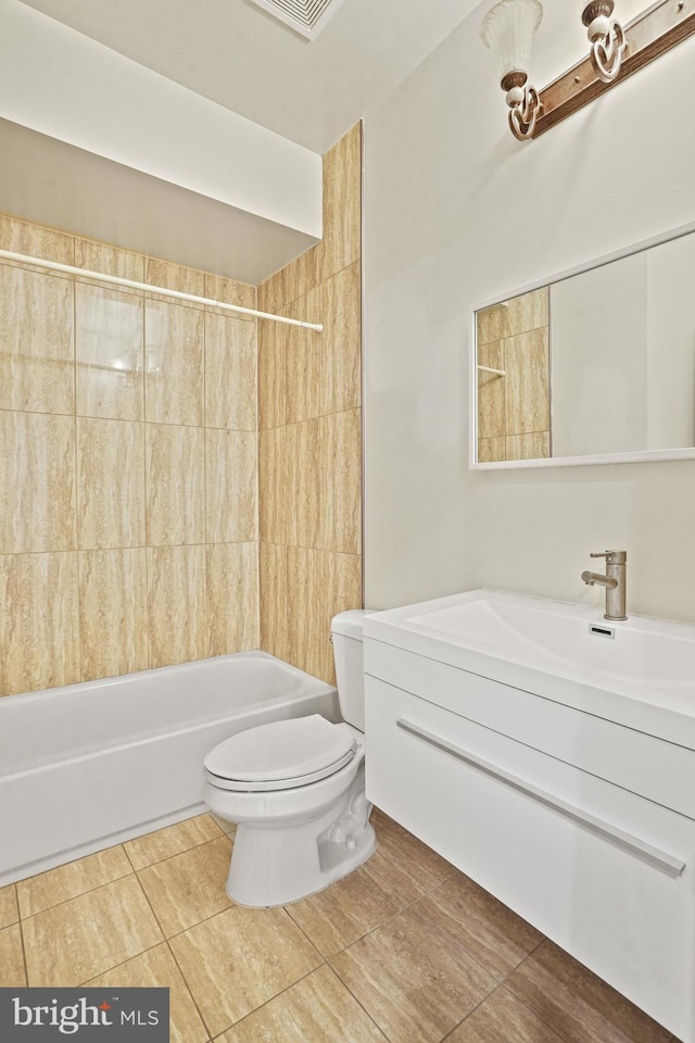 full bathroom featuring toilet, vanity, tiled shower / bath, and tile patterned flooring