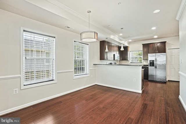 kitchen featuring dark wood-type flooring, appliances with stainless steel finishes, dark brown cabinets, decorative light fixtures, and kitchen peninsula