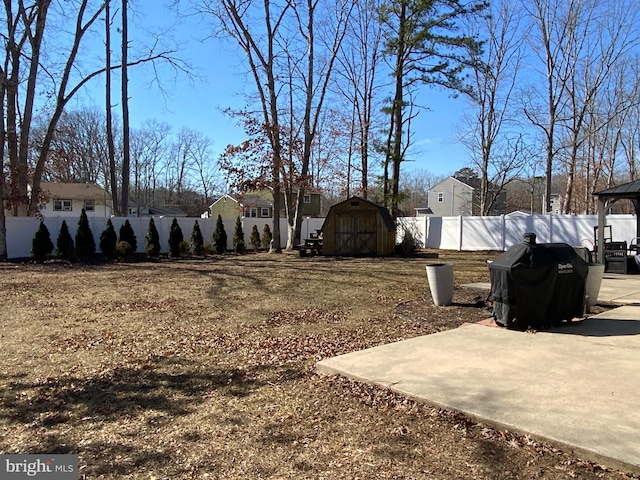 view of yard with a storage shed, a patio area, a residential view, a fenced backyard, and an outdoor structure