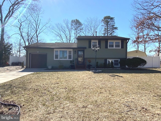 tri-level home with entry steps, a garage, fence, and concrete driveway