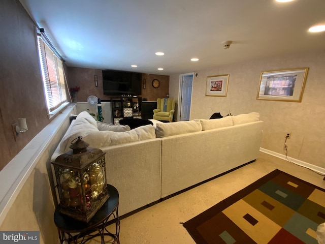 living area with baseboards, concrete floors, and recessed lighting