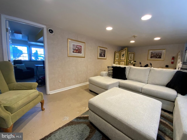 living area with baseboards, finished concrete floors, and recessed lighting