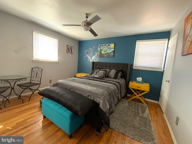 bedroom with light wood finished floors, ceiling fan, and baseboards