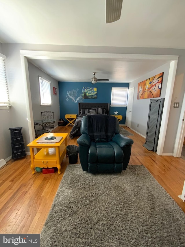 living room with a healthy amount of sunlight, ceiling fan, baseboards, and wood finished floors