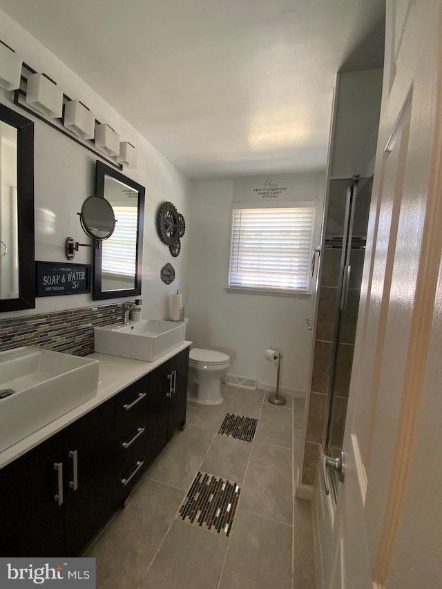 bathroom with a wealth of natural light, backsplash, and a sink