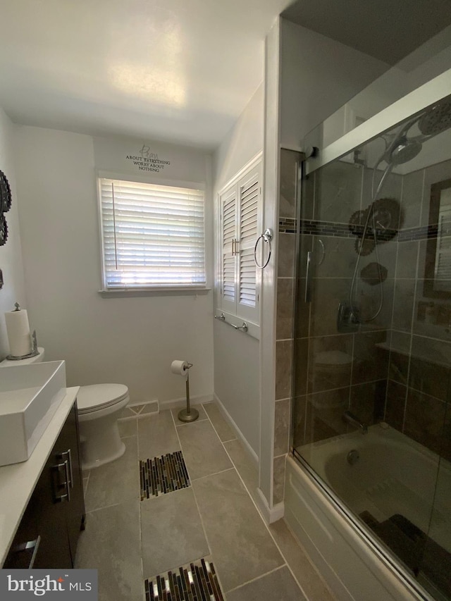 bathroom with bath / shower combo with glass door, visible vents, toilet, tile patterned flooring, and baseboards