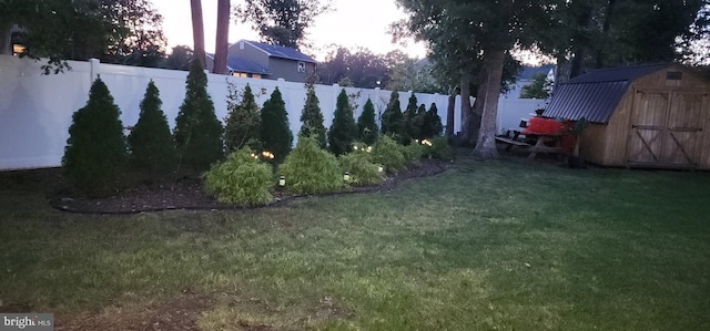 view of yard with a shed, an outdoor structure, and a fenced backyard