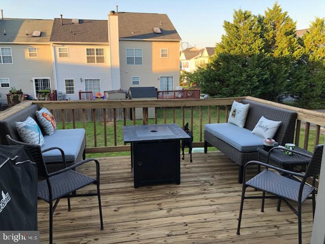 wooden terrace featuring an outdoor living space with a fire pit