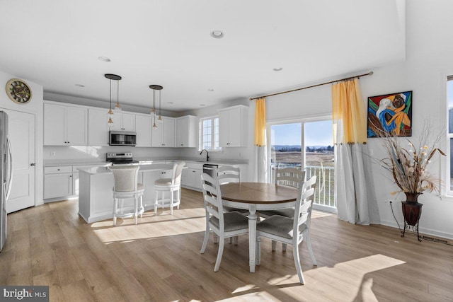 dining area with light wood-style floors and recessed lighting