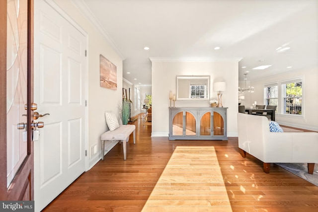 foyer entrance featuring ornamental molding, light hardwood / wood-style flooring, and a notable chandelier