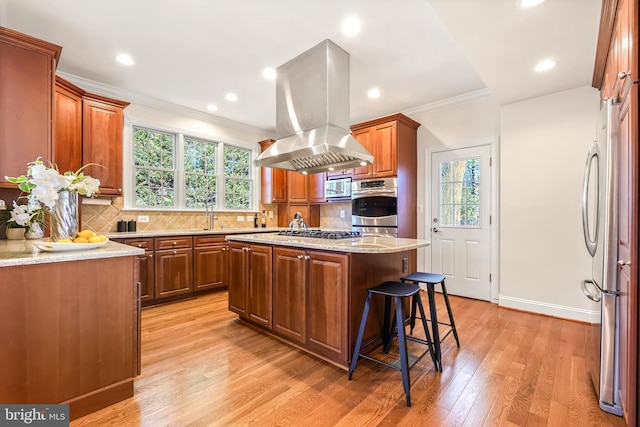 kitchen featuring appliances with stainless steel finishes, a center island, island range hood, crown molding, and tasteful backsplash