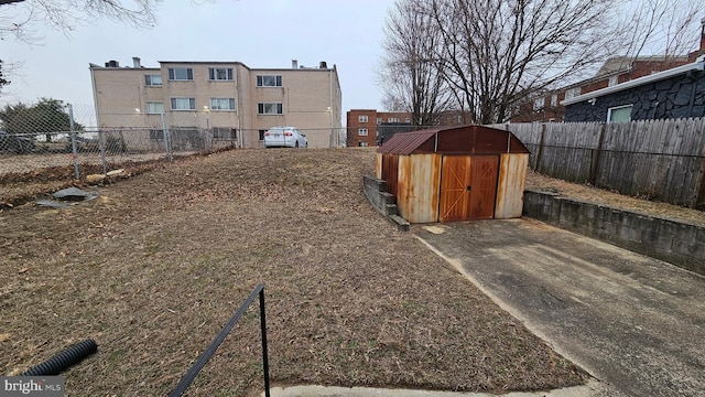 view of yard with a storage unit, fence, and an outdoor structure