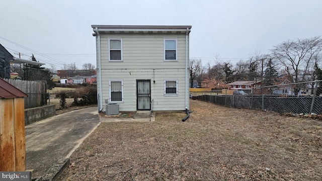 rear view of house with central AC and fence