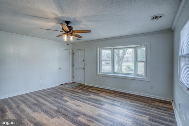 empty room featuring a textured ceiling, ornamental molding, ceiling fan, and dark hardwood / wood-style flooring