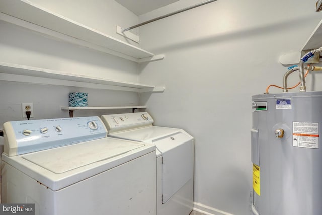 washroom with electric water heater and washer and clothes dryer