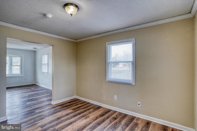 unfurnished room with dark hardwood / wood-style flooring, ornamental molding, and a textured ceiling