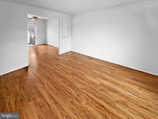 spare room with light wood finished floors, ceiling fan, and visible vents