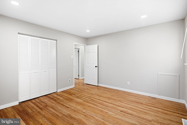 unfurnished bedroom with light hardwood / wood-style floors and a closet