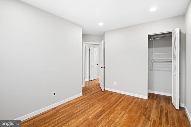 unfurnished bedroom featuring wood-type flooring and a closet