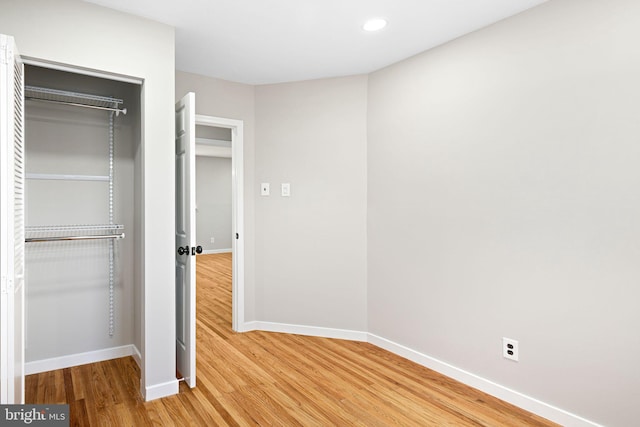 unfurnished bedroom featuring a closet and hardwood / wood-style floors