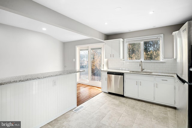 kitchen with white cabinets, plenty of natural light, stainless steel appliances, and sink