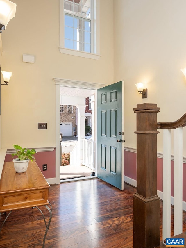 entryway with dark wood-type flooring and a high ceiling