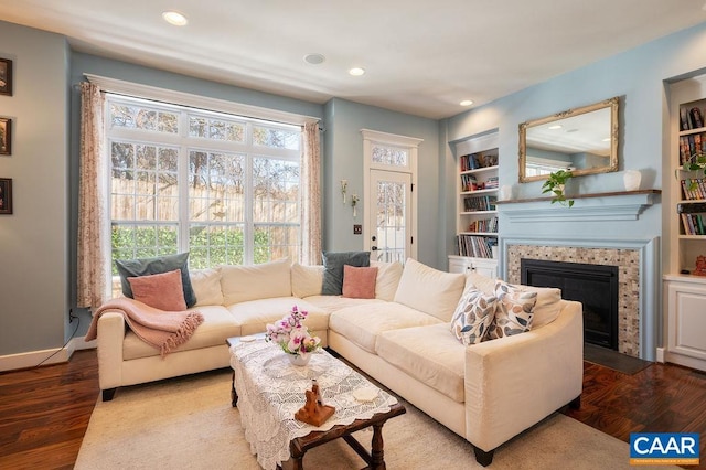 living room with a fireplace, hardwood / wood-style floors, and built in features