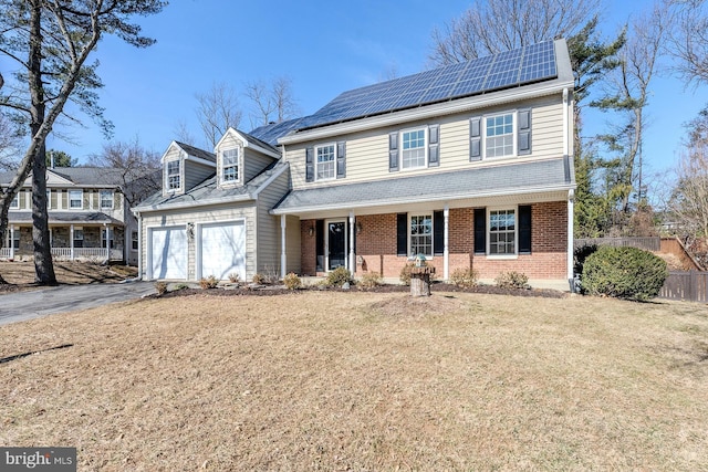 traditional-style house featuring aphalt driveway, brick siding, a porch, an attached garage, and fence