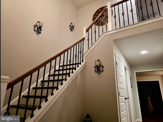 staircase with a towering ceiling and baseboards