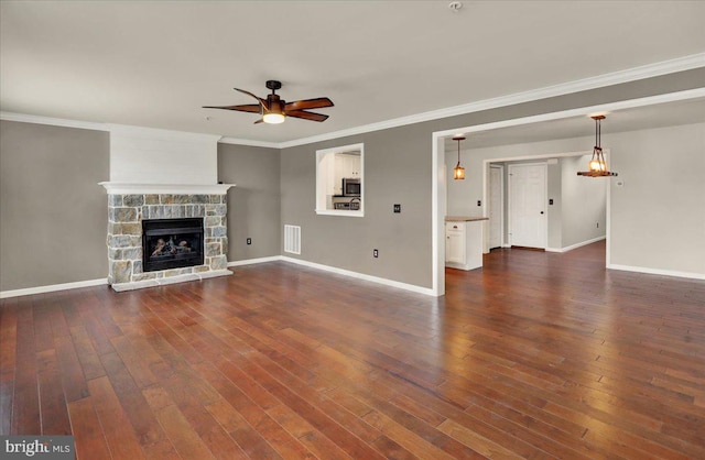 unfurnished living room with visible vents, dark wood finished floors, a ceiling fan, and a stone fireplace